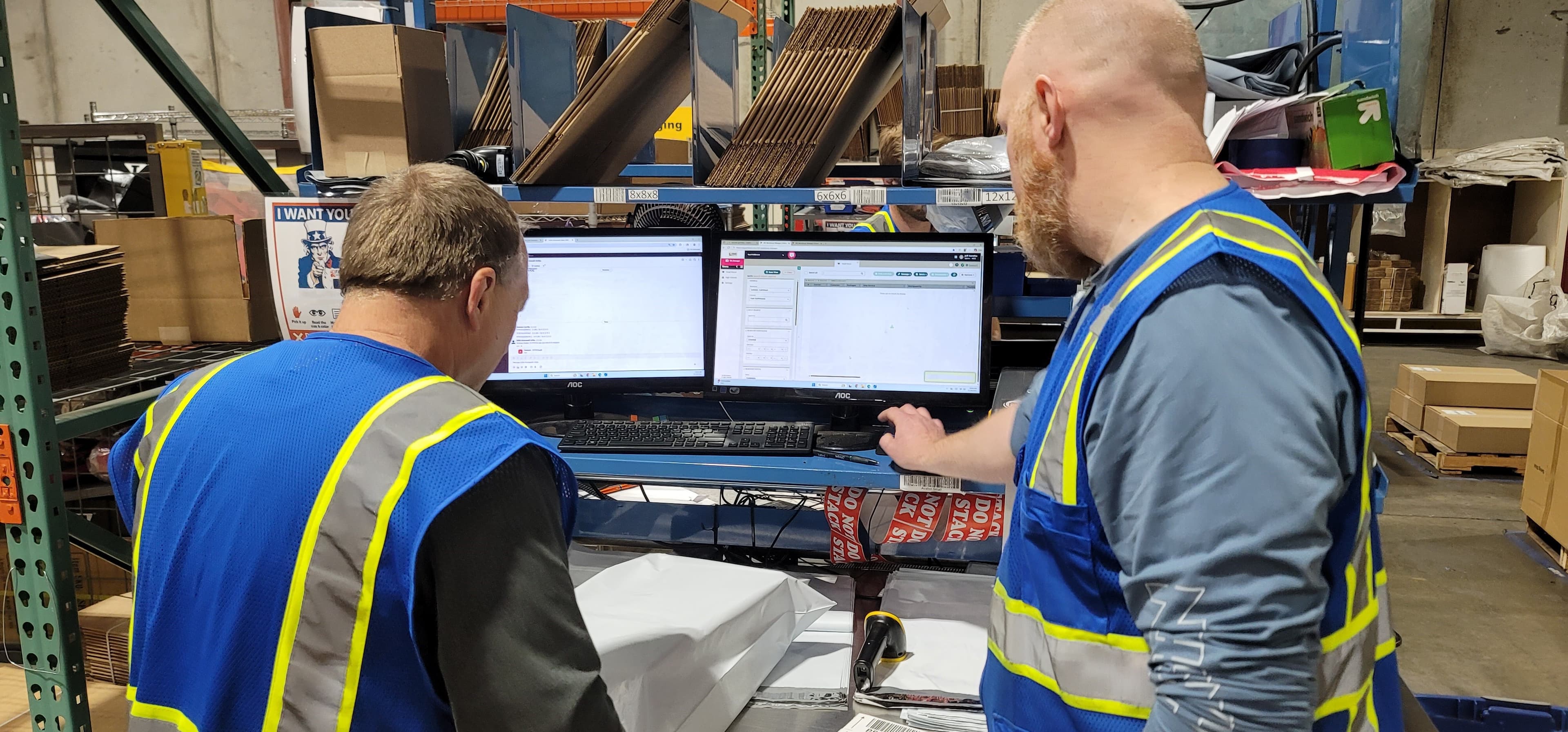 Fast Fulfillment employees working at a packing workstation inside the company's warehouse.