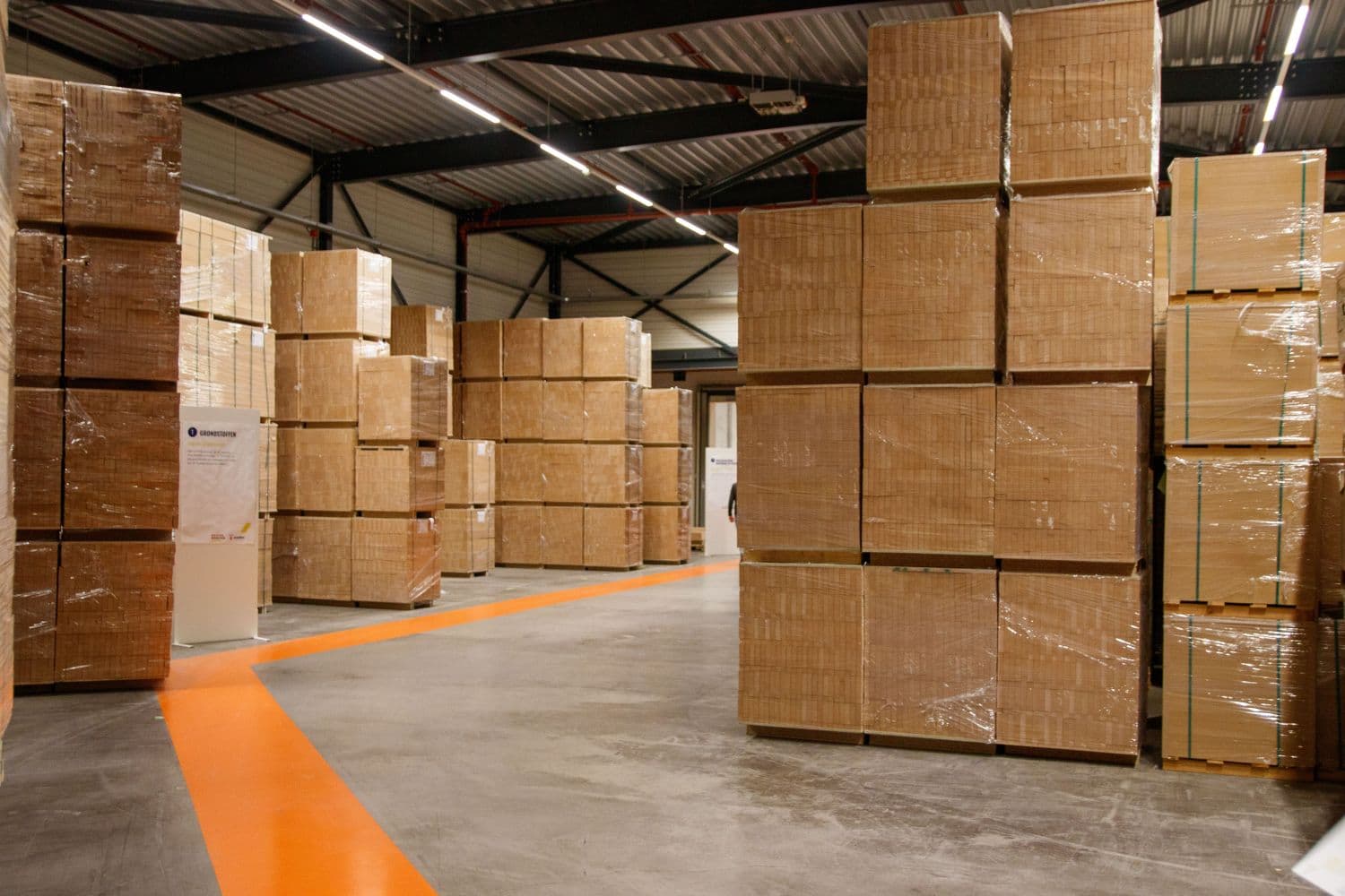 Shrink-wrapped pallets of cardboard cartons stacked inside a warehouse