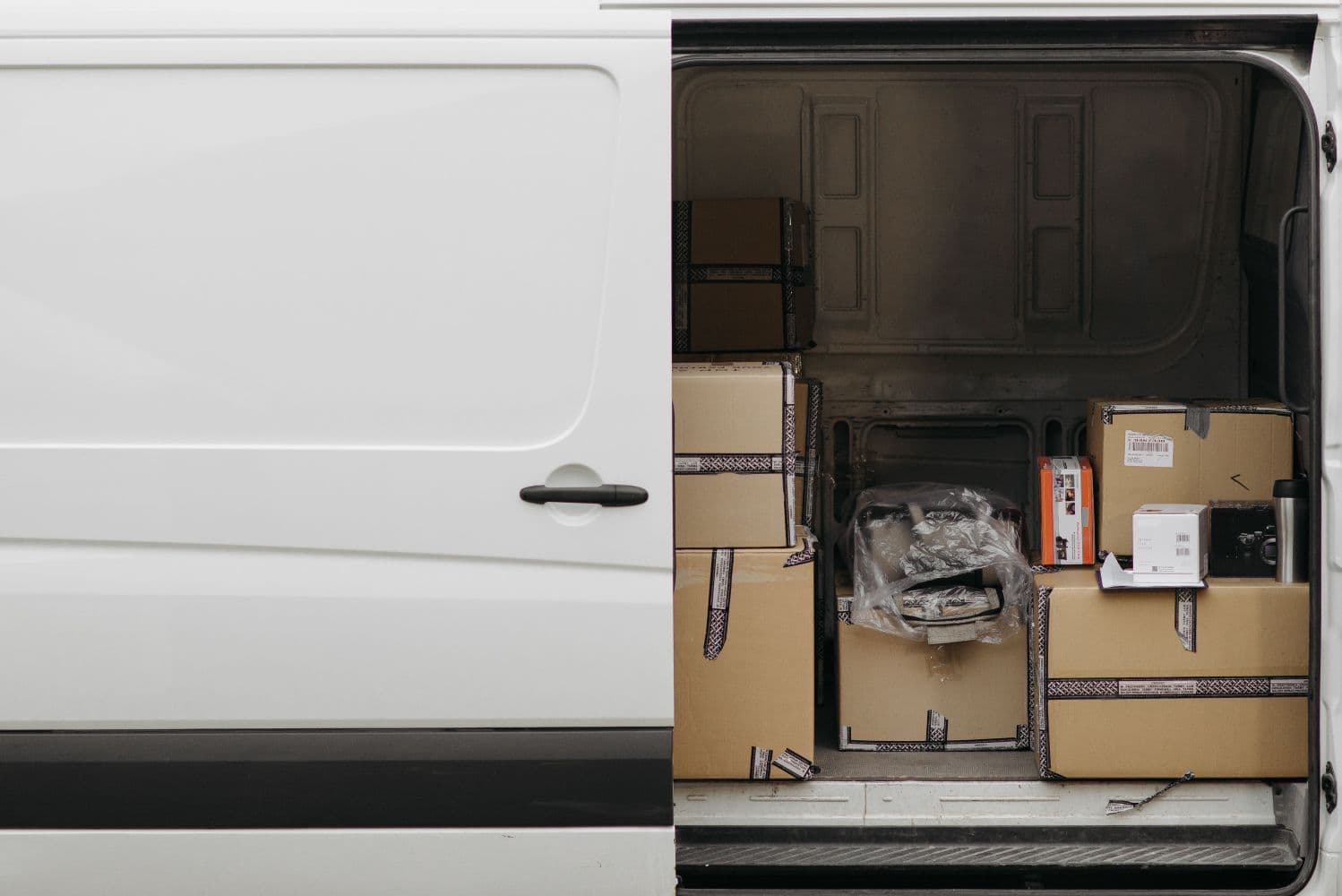 Cardboard shipping boxes of different sizes inside a delivery van